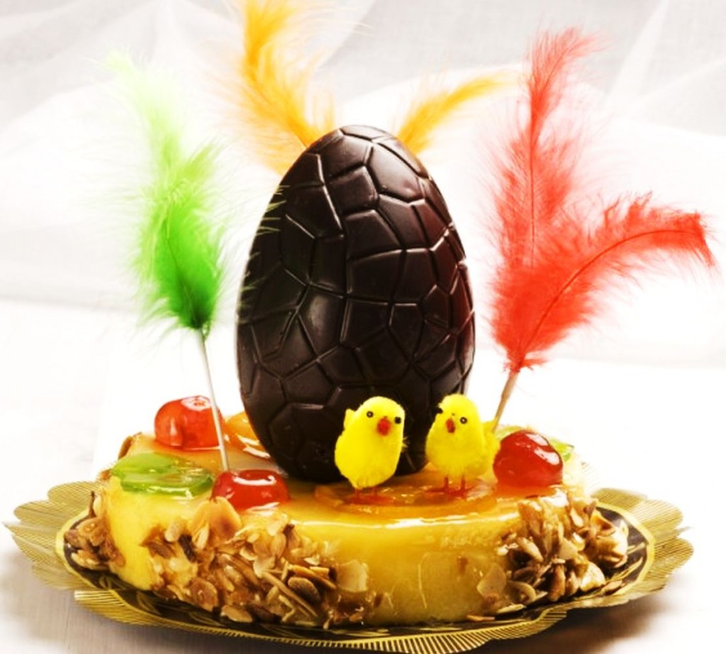 Mona de pasqua amb un ou de xocolata, plomes i pollets. 